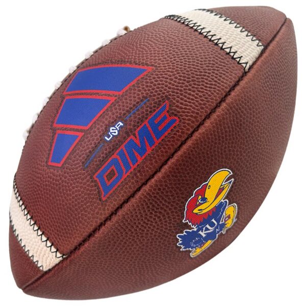 Close-up of a brown leather football with white laces, showing the DIME logo and a Kansas Jayhawks patch.