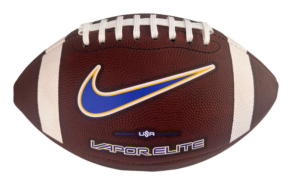 Brown American football with white laces and stripes, blue Nike swoosh, and 'USA Vapor Elite' branding.
