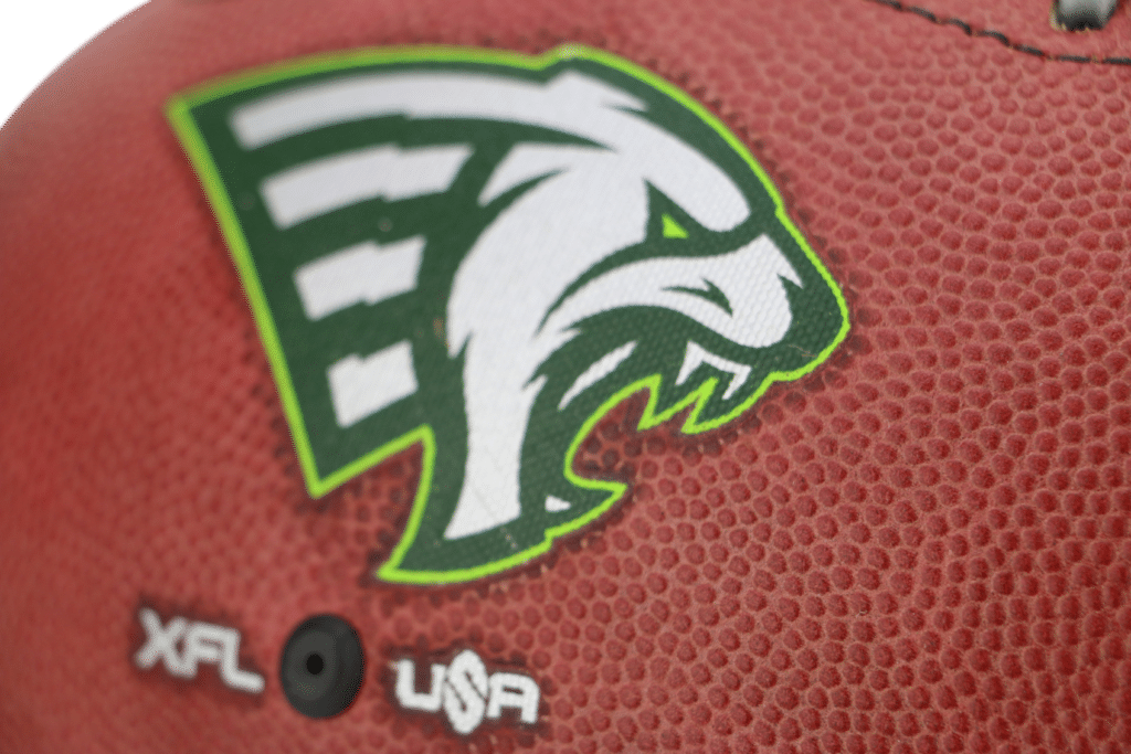 Close up of green and white Orlando Guardians logo on football for XFL