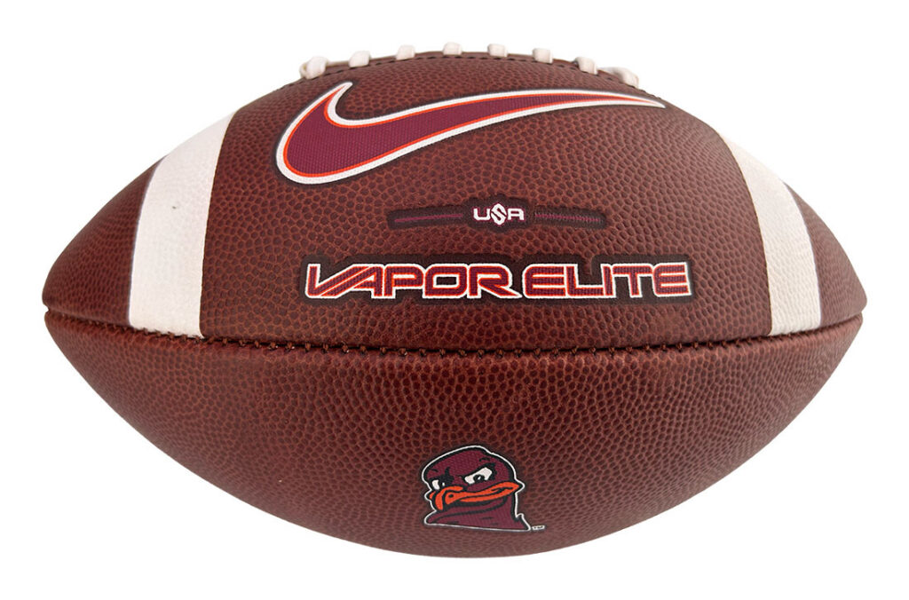 Brown leather football with white stripes, laces, and Vapor Elite branding; a small duck mascot appears on the panel.