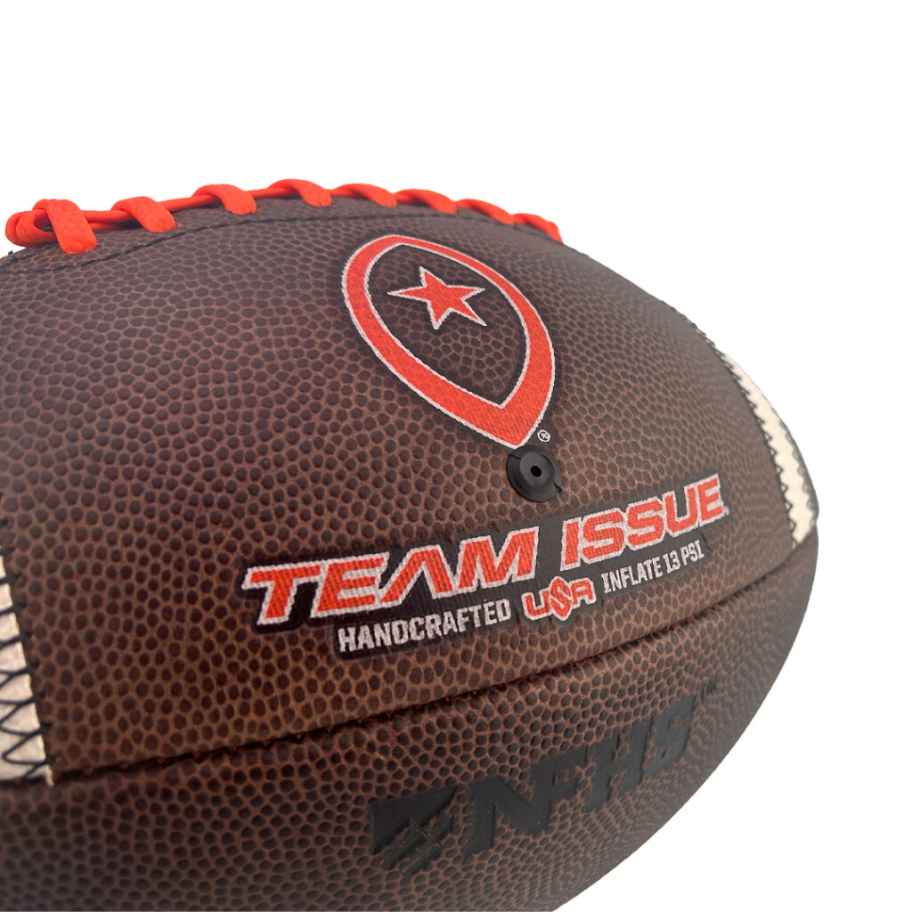 Brown leather football with red laces and team logo, close-up view highlighting stitching and 'Team Issue' branding