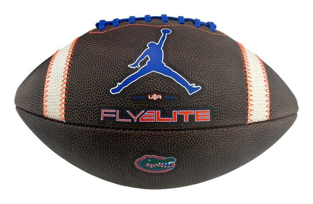 Brown leather football with blue laces, white stripe panels, and a blue Jumpman logo above the 'FLYELITE' text.