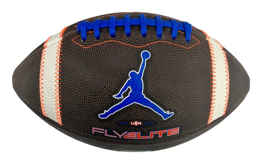 Brown American football with blue laces and orange stitching, featuring a blue Jumpman logo and the 'Fly Elite' branding.