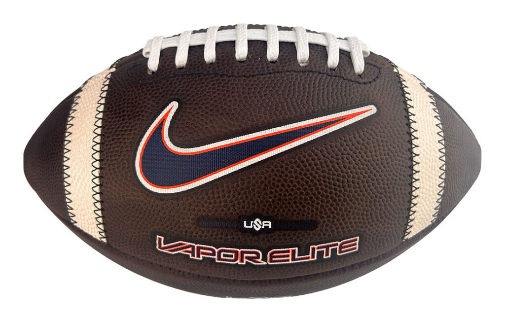 Brown leather football with white laces and beige side stripes, featuring a Nike swoosh and 'USA Vapor Elite' branding.