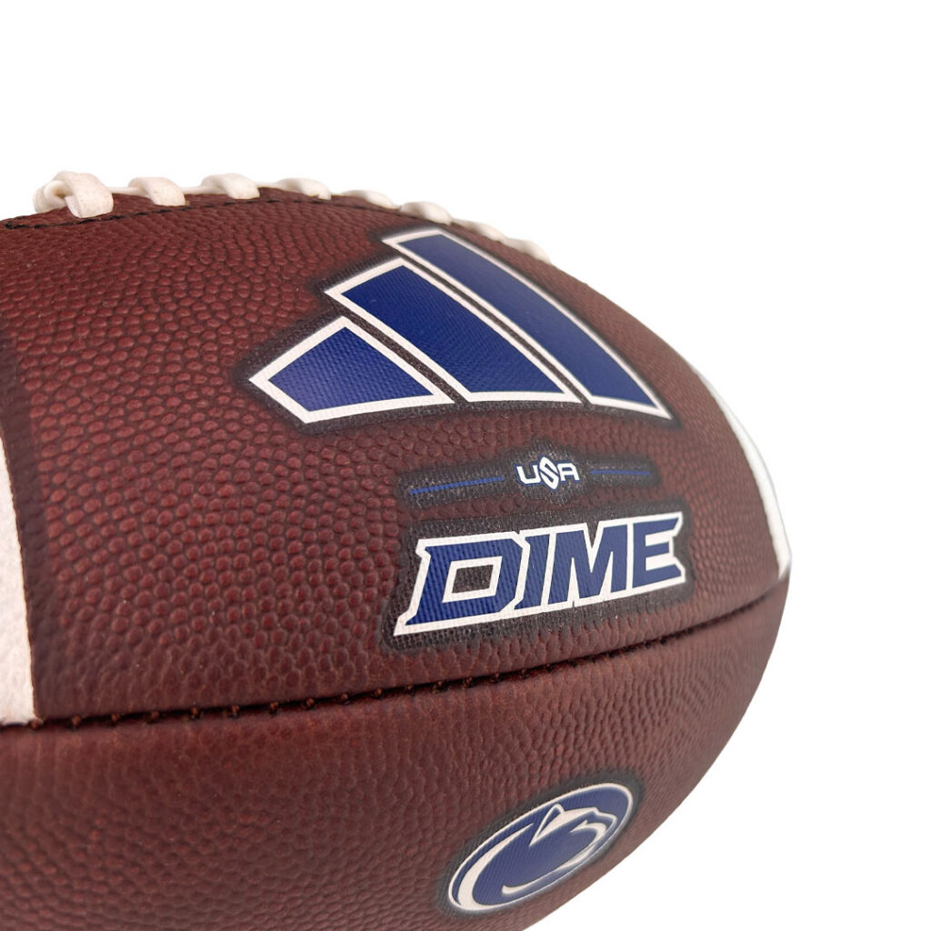 Close-up of a brown football showing a blue and white DIME logo and USA branding on the panel
