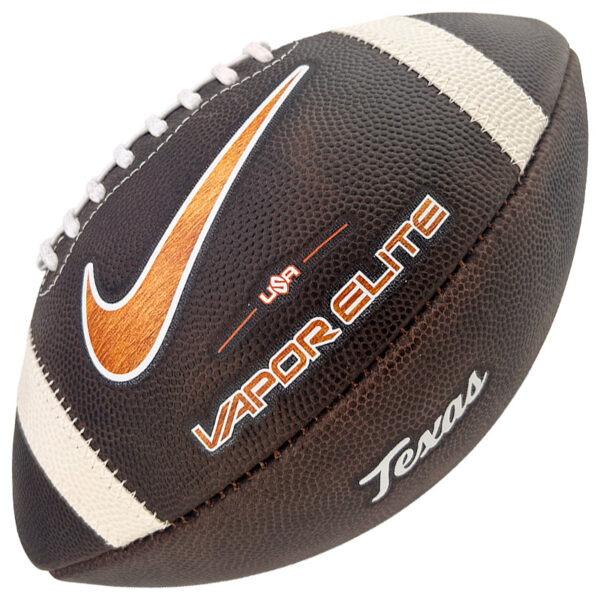 Close-up of a brown leather football showing a white laces stripe, an orange Nike swoosh, and the words 'Vapor Elite' and 'Team USA' on the surface.