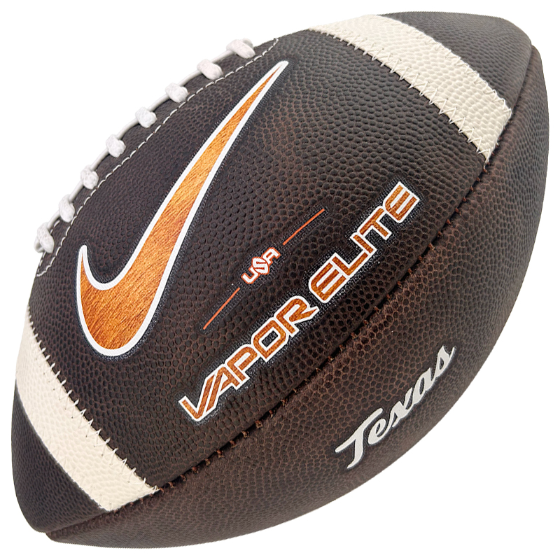Close-up of a brown leather football showing a white laces stripe, an orange Nike swoosh, and the words 'Vapor Elite' and 'Team USA' on the surface.