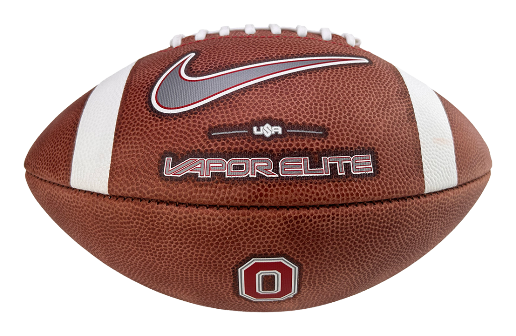 Brown football on a stand featuring a white Nike swoosh, 'VAPOR ELITE' branding, and an Ohio State block O emblem.