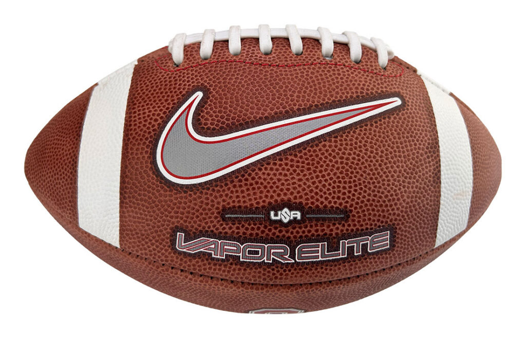 Brown leather football with white laces and stripes, featuring a silver Nike swoosh and 'Vapor Elite' text in red and white